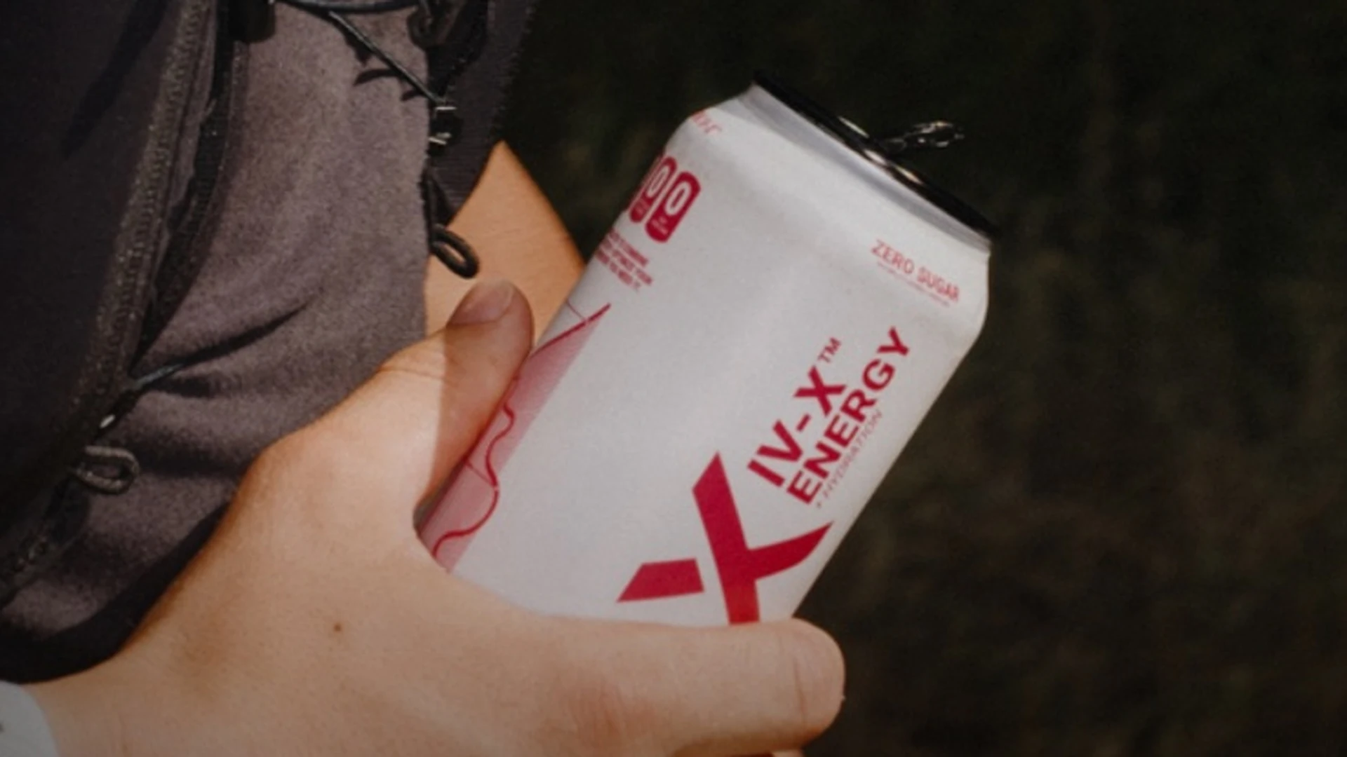 A runner holding a DRINK IV-X can in an existing product lifestyle photograph.